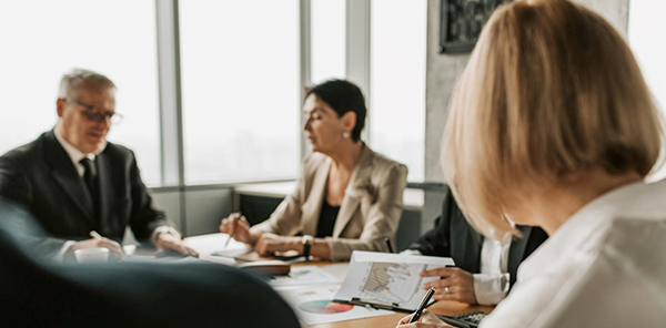 Group of professionals sit around conference room table