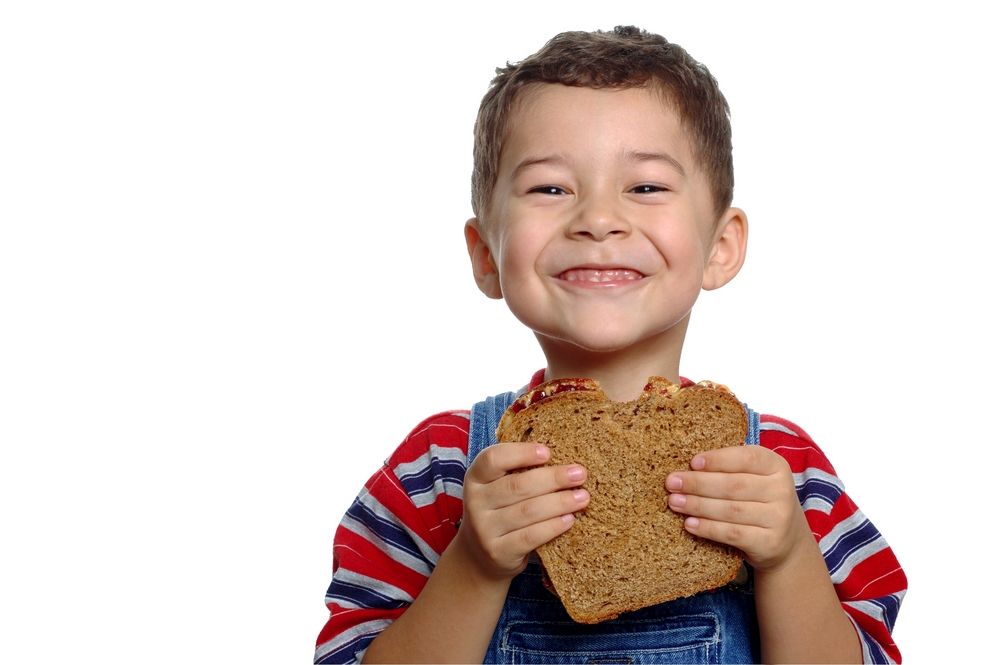 boy eating peanut butter and jelly sandwhich