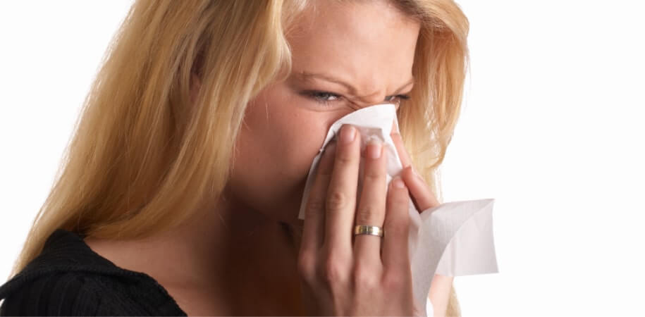 woman sneezing in tissue